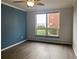 Bedroom with hardwood floors, blue accent wall, and large window at 320 S Ames St # 5, Lakewood, CO 80226