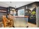 Finished basement features bar with unique corrugated metal and wooden bar, and black accent walls at 8131 S Coolidge Way, Aurora, CO 80016