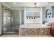 Modern bathroom featuring glass shower, soaking tub and plenty of natural light at 8131 S Coolidge Way, Aurora, CO 80016