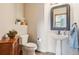 Stylish half bathroom with a pedestal sink, decorative mirror, and wood look flooring at 8131 S Coolidge Way, Aurora, CO 80016