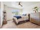 Bedroom featuring a cozy bed with blue accents, a window with natural light, and ample storage at 8131 S Coolidge Way, Aurora, CO 80016