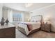 Bright bedroom with large window, neutral walls, and a comfortable bed with stylish linens and pillows at 8131 S Coolidge Way, Aurora, CO 80016