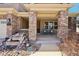 Inviting front porch with brick columns and a peaceful seating area, enhanced by rock landscaping at 8131 S Coolidge Way, Aurora, CO 80016