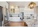 Gourmet kitchen featuring stainless steel appliances, granite countertops, and white cabinets at 8131 S Coolidge Way, Aurora, CO 80016