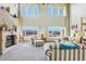 Elegant living room with a fireplace, large windows, and stylish striped furniture, creating a cozy atmosphere at 8131 S Coolidge Way, Aurora, CO 80016