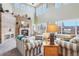 Bright living room with a stone fireplace, large windows, and comfortable striped furniture, perfect for relaxation at 8131 S Coolidge Way, Aurora, CO 80016