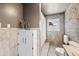 Elegant bathroom features a stone accent wall, built-in cabinet, and tile floors at 2125 Rangeview Ln, Longmont, CO 80501