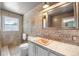Modern bathroom with stone accent wall, tile floors, and plenty of natural light at 2125 Rangeview Ln, Longmont, CO 80501