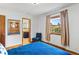 Bright bedroom boasts hardwood floors, a blue accent chair, and an ensuite bathroom at 2125 Rangeview Ln, Longmont, CO 80501