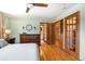 Inviting bedroom featuring wood floors, a dresser, and a view into the bathroom at 2125 Rangeview Ln, Longmont, CO 80501