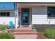Inviting entrance with a modern blue door, stone accents, and a well-maintained front yard at 2125 Rangeview Ln, Longmont, CO 80501