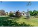 The rear of this ranch is surrounded by a spacious, well-maintained lawn and mature trees at 2125 Rangeview Ln, Longmont, CO 80501