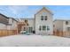 Exterior view of back of two-story home and pergola with snow covered back yard at 13353 Amber Sky St, Parker, CO 80134