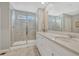 Bright bathroom featuring a double vanity with quartz countertop and a glass-enclosed shower at 13353 Amber Sky St, Parker, CO 80134