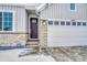 Beautiful front entrance with a brick facade, a modern black door, and a two-car garage at 13353 Amber Sky St, Parker, CO 80134