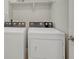 Bright laundry area with modern appliances, a washer and dryer, and a white shelf overhead at 13353 Amber Sky St, Parker, CO 80134