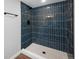This is a bathroom with blue tiled shower and a pebble style shower floor at 5304 Granby St, Denver, CO 80239