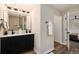Well-lit bathroom with double sink vanity, modern fixtures, and wood-look flooring at 5304 Granby St, Denver, CO 80239