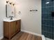 This is a bathroom with a wood vanity and blue tiled shower at 5304 Granby St, Denver, CO 80239