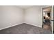 Empty bedroom with neutral carpet and walls; door leads to main bedroom at 5304 Granby St, Denver, CO 80239
