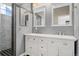 Bathroom featuring a double vanity with modern fixtures and a tiled shower with glass doors at 16212 E Geddes Ln # 11, Aurora, CO 80016