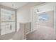 Upstairs hallway view leading into a bright bedroom with a ceiling fan and ample natural light at 16212 E Geddes Ln # 11, Aurora, CO 80016
