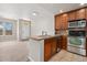 Modern kitchen with stainless steel appliances and rich wood cabinetry, seamlessly connected to the living area at 16212 E Geddes Ln # 11, Aurora, CO 80016