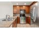 Modern kitchen with stainless steel appliances, granite countertops, and wood cabinets at 16212 E Geddes Ln # 11, Aurora, CO 80016