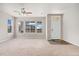 Bright living room features large windows, neutral carpet, and a ceiling fan, creating a welcoming atmosphere at 16212 E Geddes Ln # 11, Aurora, CO 80016