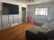 Casual living room with hardwood floors, a gray sofa, and natural light from the window at 7488 Quivas St, Denver, CO 80221