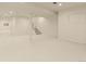 A clean, open basement with neutral carpet and white walls at 10293 E Sheri Ln, Englewood, CO 80111