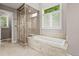 Updated bathroom with a soaking tub, glass shower, and large window at 10293 E Sheri Ln, Englewood, CO 80111