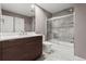 Modern bathroom with gray tile, a dark vanity, a glass-enclosed shower and a toilet at 10293 E Sheri Ln, Englewood, CO 80111
