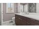 Bathroom with a vanity, light fixtures, gray tile floors, and a shower with a sliding glass door at 10293 E Sheri Ln, Englewood, CO 80111