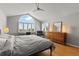 Primary bedroom featuring hardwood floors, ceiling fan, large windows and a dresser with decorative lamps at 10293 E Sheri Ln, Englewood, CO 80111