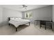 Bright bedroom with a ceiling fan, a black bed frame, and a writing desk with natural light from the window at 10293 E Sheri Ln, Englewood, CO 80111