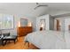 Large primary bedroom features hardwood floors, ceiling fan, dresser and a chair at 10293 E Sheri Ln, Englewood, CO 80111