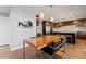 Modern dining room with wood table, sleek chairs, and a view into the kitchen and appliances at 10293 E Sheri Ln, Englewood, CO 80111