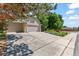 Long driveway leading to a three-car garage, accented by manicured landscaping and mature trees at 10293 E Sheri Ln, Englewood, CO 80111