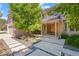 Inviting entrance with a covered porch, double wooden doors, and stepping stone pathway surrounded by plants at 10293 E Sheri Ln, Englewood, CO 80111