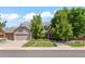 Beautiful two-story home with a well-manicured lawn, mature trees, and a three-car garage at 10293 E Sheri Ln, Englewood, CO 80111