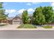 Beautiful two-story home with a well-manicured lawn, mature trees, and a three-car garage at 10293 E Sheri Ln, Englewood, CO 80111