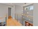 Second-floor hallway features hardwood floors, metal railings, and modern lighting fixture at 10293 E Sheri Ln, Englewood, CO 80111