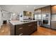 Modern kitchen with center island, wood cabinetry, stainless steel appliances, and sleek design in an open-concept living space at 10293 E Sheri Ln, Englewood, CO 80111