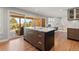 Open-concept kitchen with island, bar seating, wood cabinets, stainless appliances and view of the outdoor patio and dining area at 10293 E Sheri Ln, Englewood, CO 80111