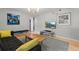 Open living area with modern decor, wood floors, and large television and views of the hall and stairwell at 10293 E Sheri Ln, Englewood, CO 80111