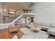 Spacious living room featuring a staircase, modern railing, and comfortable seating area with a large area rug at 10293 E Sheri Ln, Englewood, CO 80111