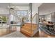 Modern staircase featuring wooden steps, stainless steel railings, and abundant natural light at 10293 E Sheri Ln, Englewood, CO 80111