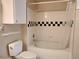 Tiled bathtub and shower with black and white checkerboard design add a touch of sophistication at 1659 Harris St, Superior, CO 80027