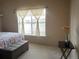 Bright bedroom with a flower arrangement, ottoman bench, and a window with blinds at 1659 Harris St, Superior, CO 80027